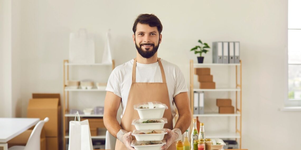 a food handler fills two containers with sliced tomatoes for sandwiches later in the week